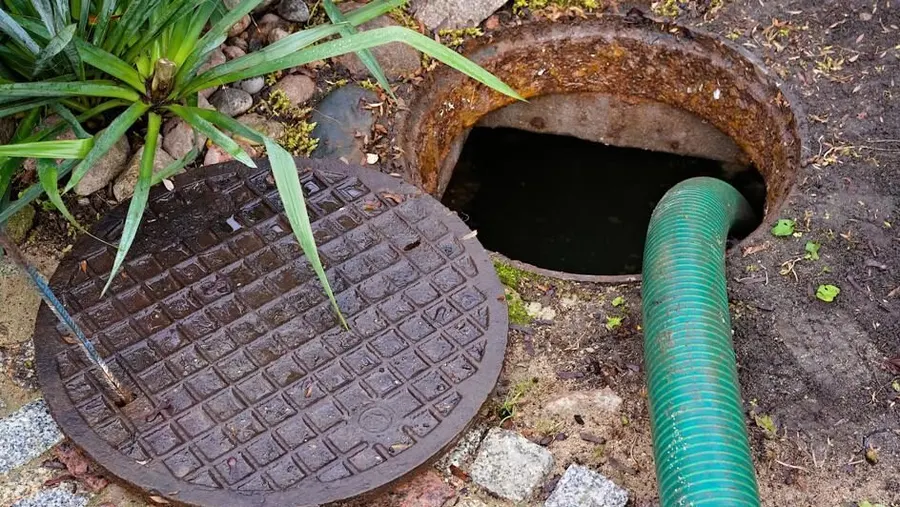 A Durham Region Septic Pumping technician cleaning out a residential septic tank.